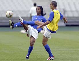 Brazilian midfielder Ronaldinho and forward Adriano fight for the ball