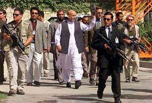 Afghanistan President Hamid Karzai waves to presidential palace workers