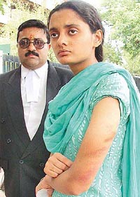 Radhima, along with a human rights activist, shows injury marks on her shoulder