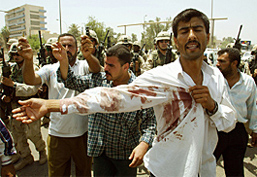 An Iraqi protester shows his blood-stained shirt after the US troops killed two people in Baghdad 