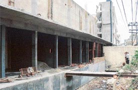 Construction work in progress on municipal land along a nullah in the books market in Ludhiana. In the background