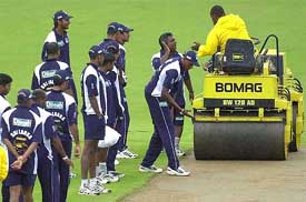 Sri Lanka's coach Duleep Mendis listens to a report from a field worker