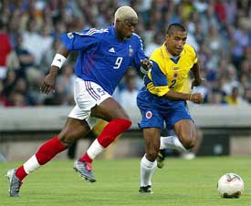 Dijbril Cisse of France and Colombia captain Ivan Cordoba run for the ball