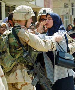 US soldiers restrain an angry woman