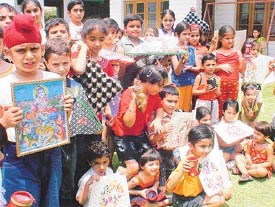 Children show their paintings, wall hangings and other craft items on the concluding day of their summer camp