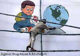 A painter works on an anti-drug campaign billboard