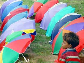 A young umbrella vendor waits for customers