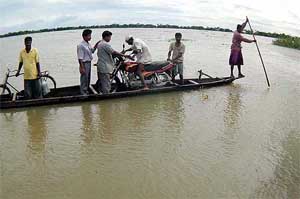 People cross in boats in the flood-affected Chorabori village