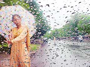 A young girl with an umbrella as The Tribune cameraman Karam Singh clicks her through the rear view mirror of his car as Chandigarh gets first pre-monsoon showers on Monday.