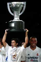 Real Madrid's Portuguese player Luis Figo raises a replica of the Spanish League title cup
