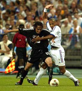 Thierry Henry of France struggles for the ball with Chris Bouckenooghe of New Zealand