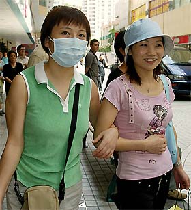 A resident of Amoy Gardens, the worst-hit residential apartments in Hong Kong by SARS virus, shops while wearing a mask