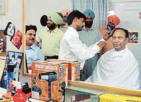 Beautician-turned-constable Ehsan Ali, popularly known as Salman, making Mr D.R. Bhatti, Additional Director-General of the Punjab police, tidy at the newly opened police saloon in Sector 39, Chandigarh
