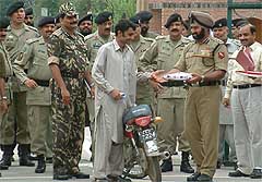 One of the six Pakistani nationals released by the Indian Government crosses over to his country on his motor cycle from the joint check-post at Wagah