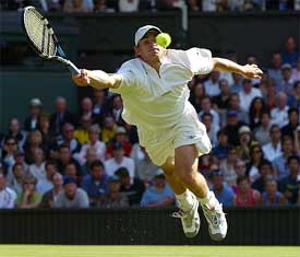 Andy Roddick of the US leaps to play a return to Britain's Greg Rusedski