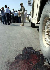 A pool of blood is seen on the ground by the side of an undamaged US army vehicle near Baghdad airport