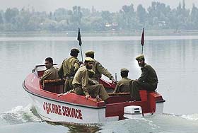 Policemen use a boat to patrol Dal Lake