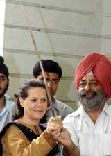 Congress President Sonia Gandhi holds a sword presented by the Sikh community in New Delhi on Friday after the Delhi Government declared Punjabi as the second language after Hindi.