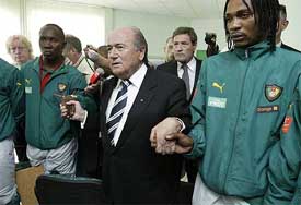 FIFA president Sepp Blatter joins hands with members of the Cameroon national soccer team