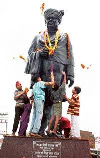 Children shower flowers on the statue of former Deputy Prime Minister Devi Lal