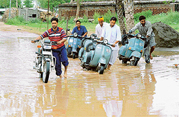 Commuters on the SAS Nagar-Zirakpur road, near Kandala village, wade through a 200-metre stretch inundated with rainwater.