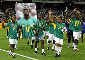 The Cameroon soccer team does the honour lap holding a portrait of their deceased team-mate Marc-Vivien Foe