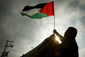 A Palestinian security guard puts a flag on a security post after Israeli troops pulled back from Gaza Strip on Monday