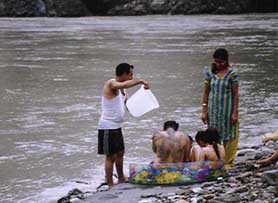 Tourists enjoy a bath at Tatapani 
