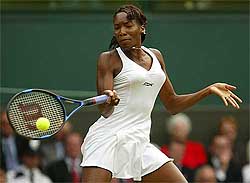Venus Williams of the US makes hits a forehand return to compatriot Lindsay Davenport