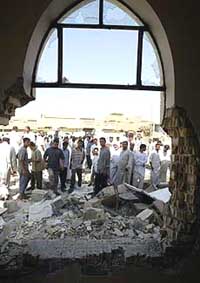 Iraqis look at a huge hole in a mosque, caused by a blast which killed at least five persons 