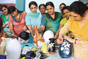 A teacher of Home Science College, Punjab Agricultural University, demonstrates how to paint a pot at a short course in Ludhiana on Wednesday.