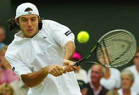 Sebastien Grosjean of France returns to Britain's Tim Henman