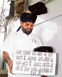 Mr Satpal Puri, a councillor, protests against the non-availability of funds, while on way to the MC meeting