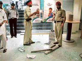 Police personnel at the Reliance office which was attacked by a mob