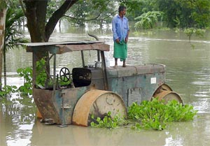A man stands atop his vehicle, to protect himself from the floodwaters