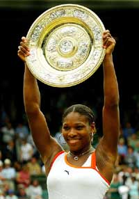 Serena Williams of the US holds up the winner's trophy after defeating her sister Venus Williams in the women's singles final at the Wimbledon Tennis championships