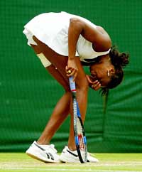 Venus Williams of the US doubles up during her women's singles final match against sister Serena
