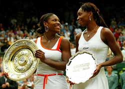 The Williams sisters, Serena and Venus, smile as they hold their trophies