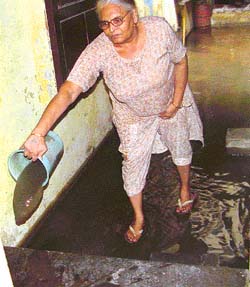 A woman throws out sewage collected in her house in Lajpat Nagar, Ludhiana, on Sunday.