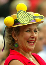 A woman with an out of the ordinary hat on her head watches the men's singles final 