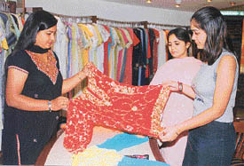Customers admire an embroidered kurti at a store 