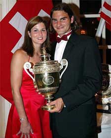 Switzerland's Roger Federer, accompanied by girlfriend Miroslava Vavrinec, shows off his winner trophy