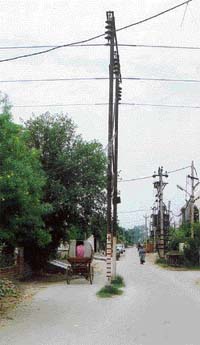 An electricity pole that stands in the middle of a road 