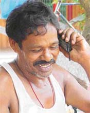Munna Lal, a roadside vendor in Ludhiana, uses a mobile to contact his family at Farookhabad in Uttar Pradesh