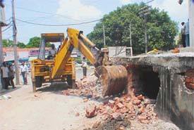 A JCB of the MC demolishes a newly constructed basement of a building near Dandi Swami Temple