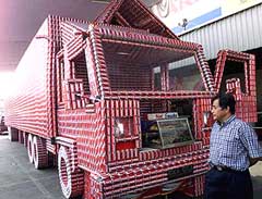 A visitor takes a look at a truck made out of 57,000 empty soft drink cans at a mall in Jakarta
