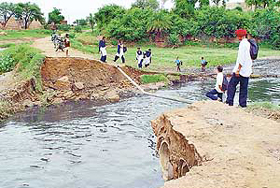 Schoolchildren on one end of Manoli village wait for their classmates on the other side, who could not make it to the school today following the collapse of the Manoli bridge, in SAS Nagar on Friday.