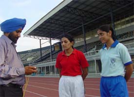 Rajni and Rupinder budding athletes take tips from their coach Mr Prem Singh at Guru Nanak Stadium in Ludhiana