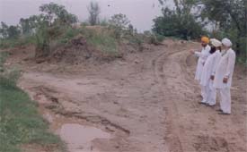 Villagers show a weakened portion of a bundh at Kasabad village on Saturday