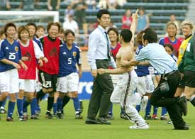 An unidentified Mexican streaker dashes across the pitch as the Japanese national women�s soccer team laughs